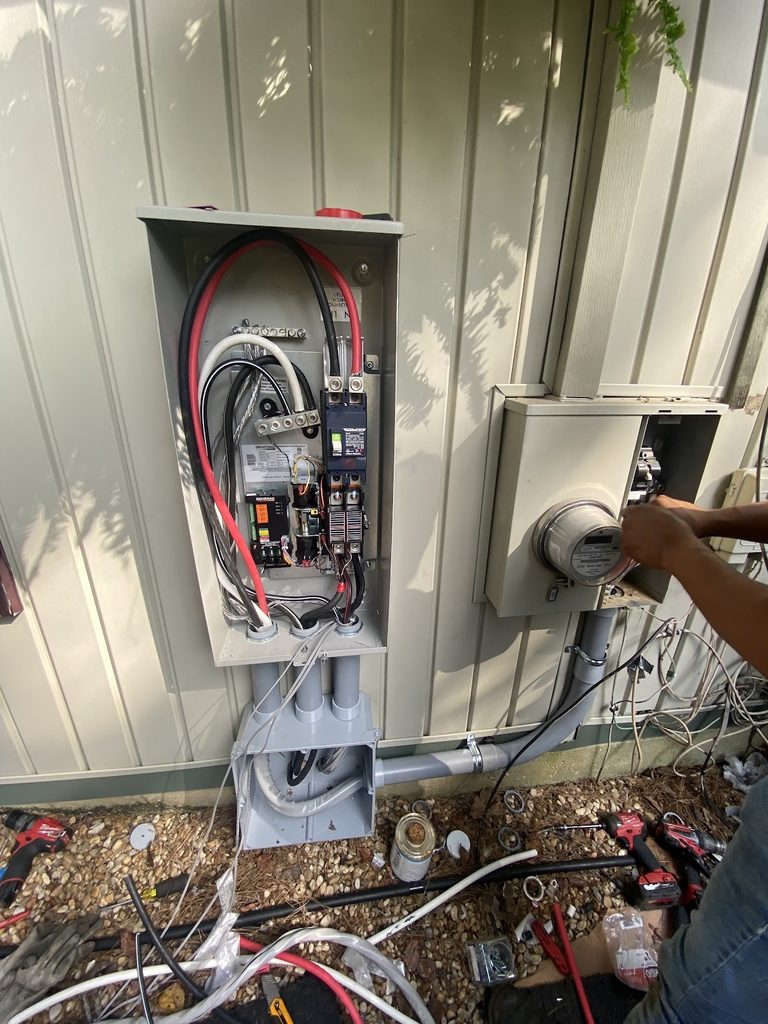 Volt Electric electrician working at a meter beside a Generac transfer switch in west Metro Atlanta